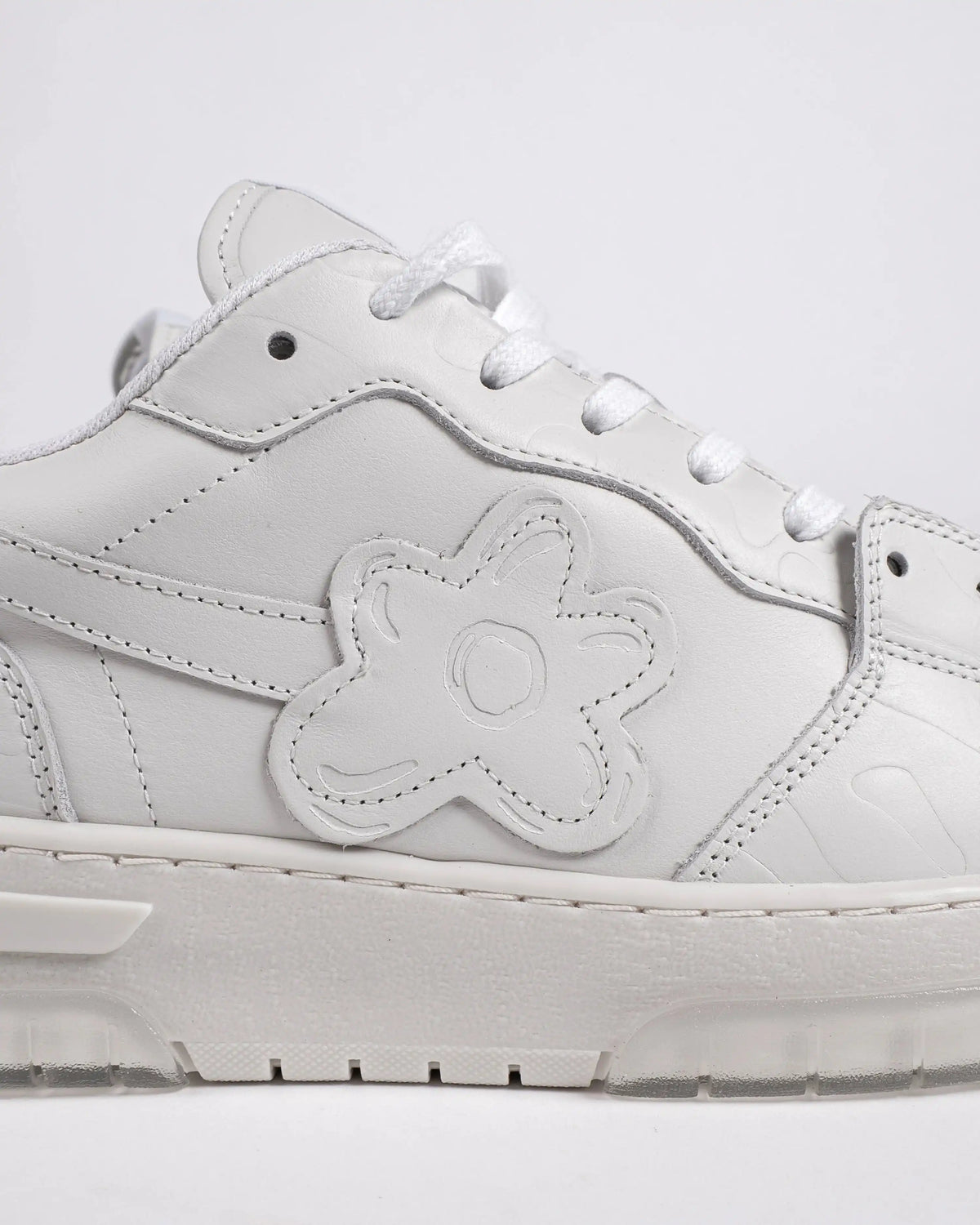 Le motif floral est imprimé en relief dans le cuir italien blanc. Fait main au Portugal.