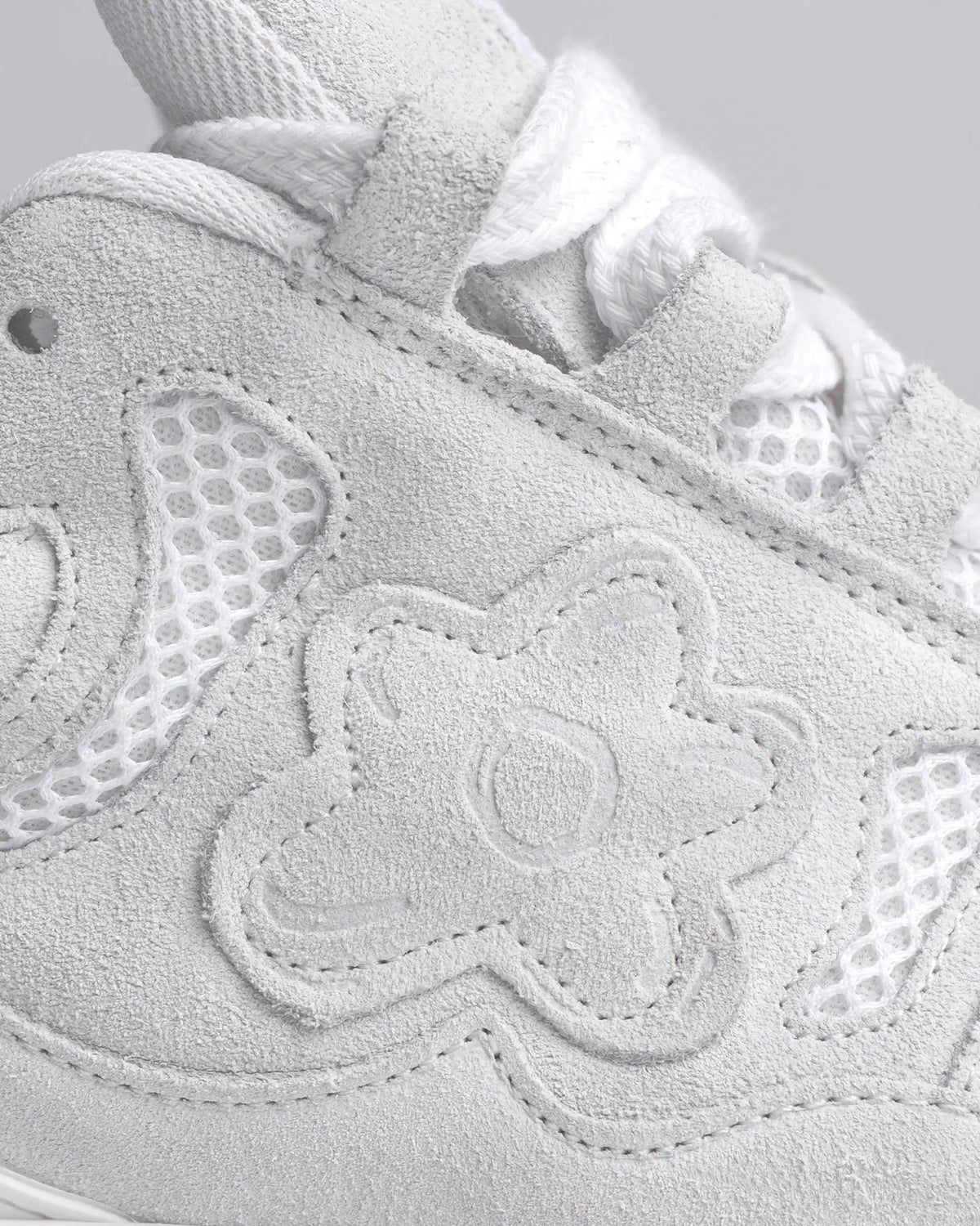 Une Fleur en daim ton sur ton sur une chaussure toute blanche. Fait main au Portugal.