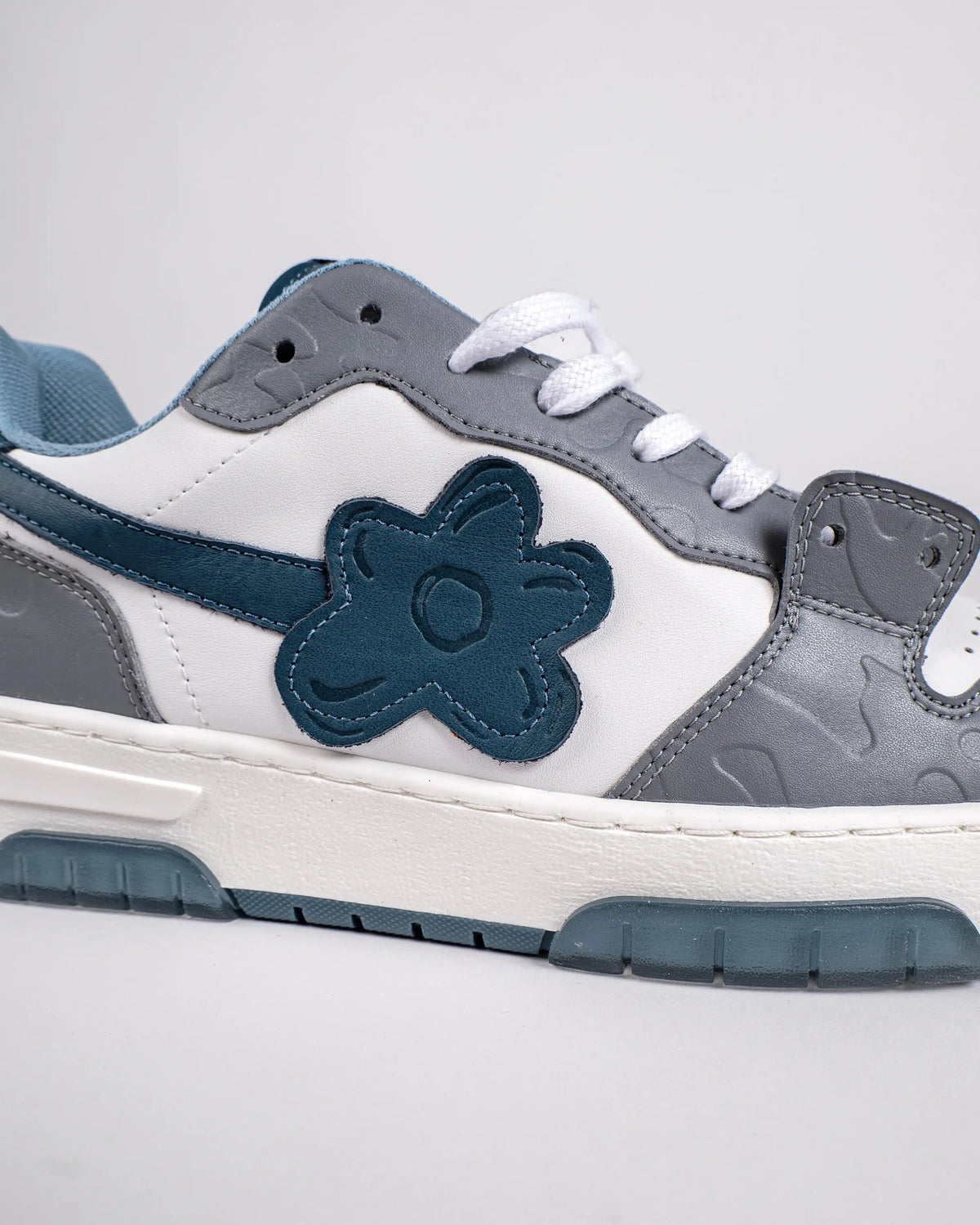 Flin Cloud Berry, close-up of the navy Flower on the side and the grey leather panels