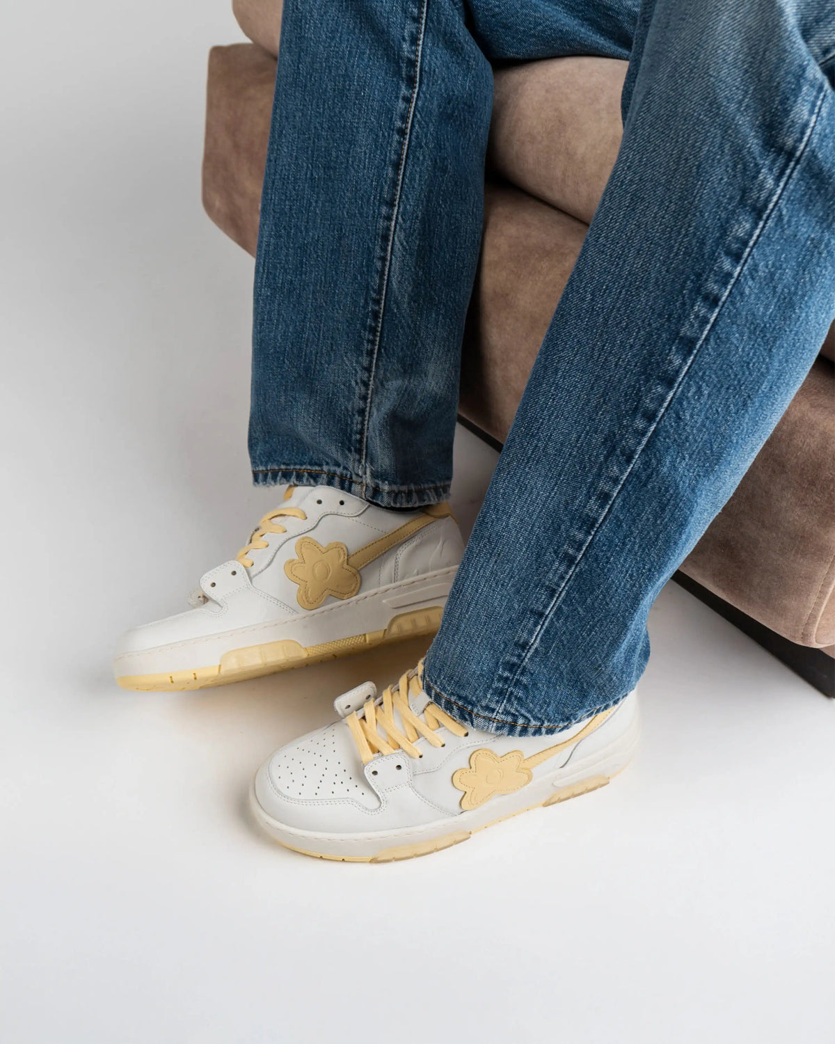 Flin Sun Pollen worn with blue jeans, feet crossed, seated